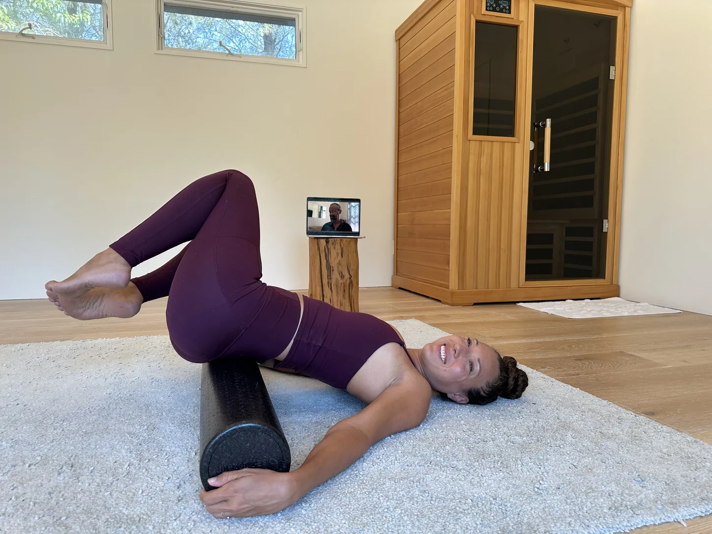 A woman following the Living Practice on her laptop
