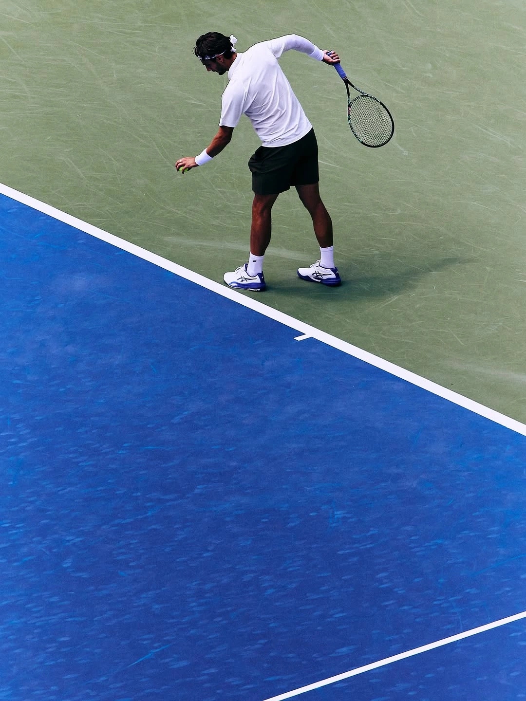 A tennis player moving across the court